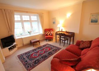 A Somerset holiday apartment lounge with comfortable sofa, TV and side tables.