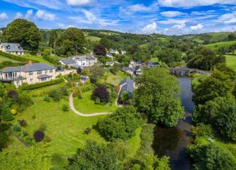 Aerial view of an Exmoor river valley overlooked by village cottages.