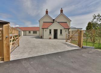 Atwin-gabled contemporary house with a large drive and secure fenced garden.