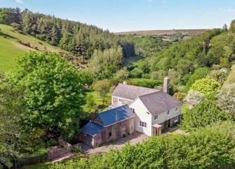 A large Exmoor holiday cottage nestles in a wooded valley.
