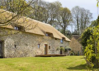 A n ewly thatched Devon cottage overlooking a spacious lawn.