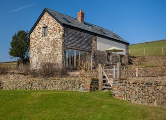 A stone-built Exmoor barn conversion in open countryside.