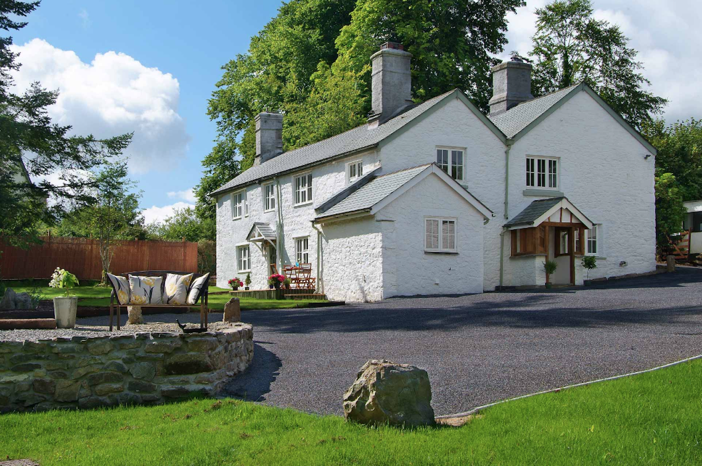 Exterior of a large Manor House overlooking a spacious lawned garden.