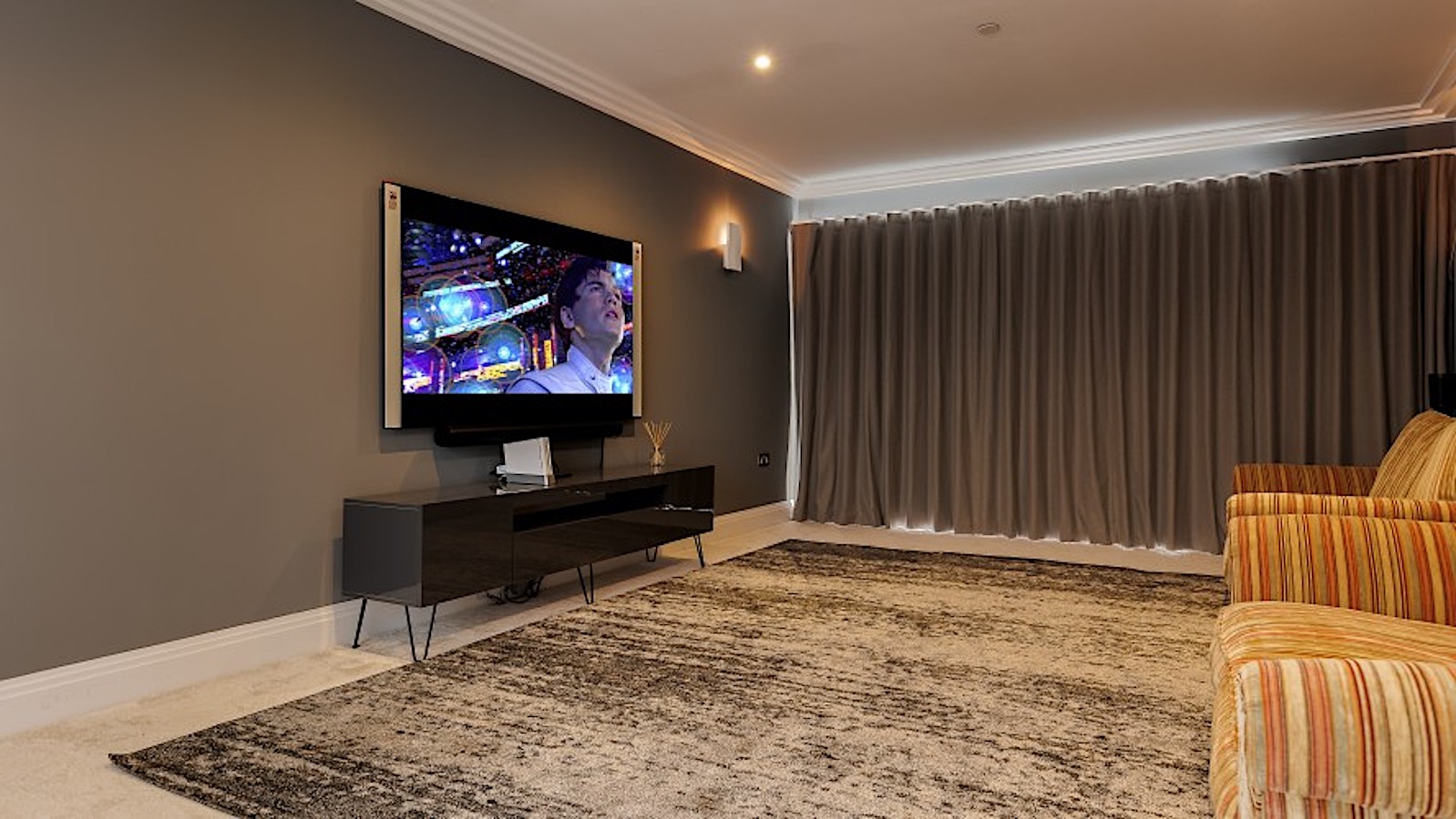 A cinema room with armchairs and wide screen in a large holiday cottage