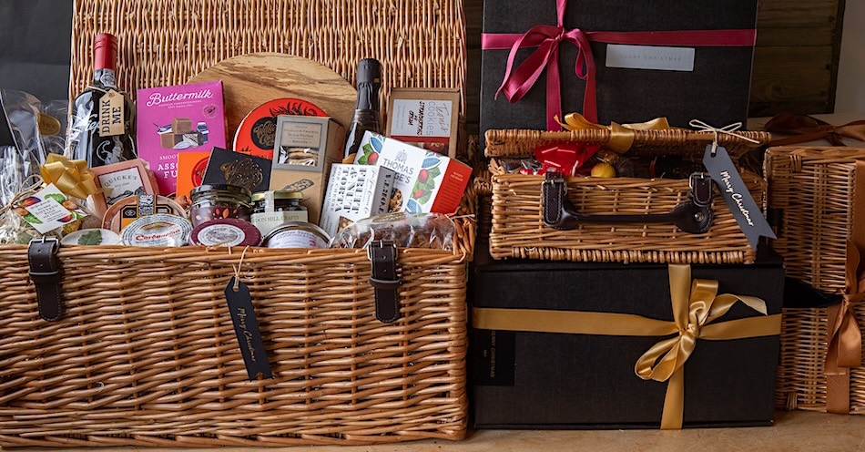 Wicker hampers filled with packets and jars of luxury food items.