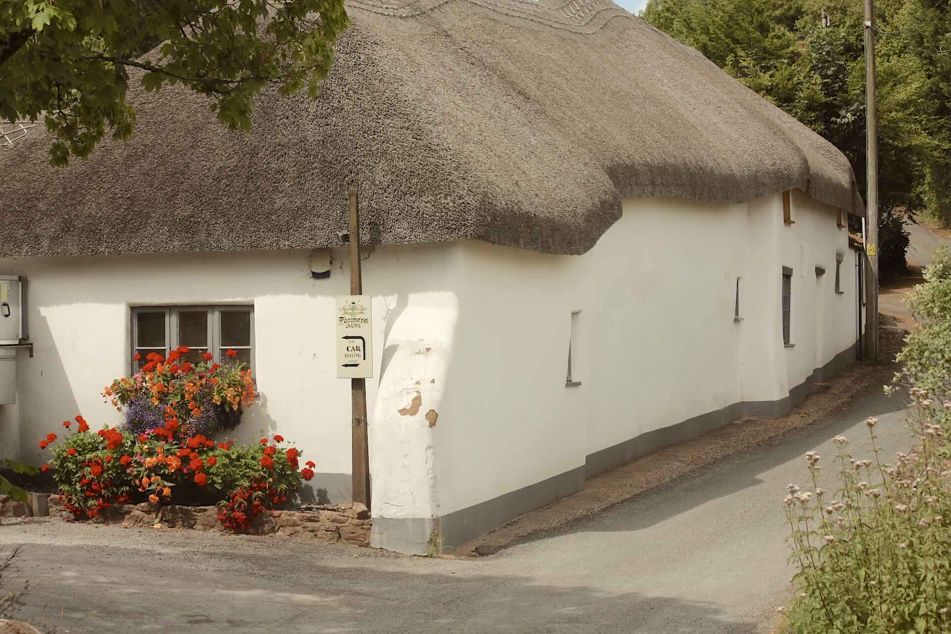 The exterior of a white-washed thatched village pub in the Quantock Hills