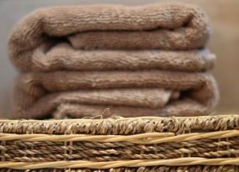 A neatly folded luxury towel on top of a wicker basket