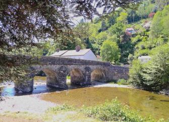 A 5-arched stone bridge crosses the wide shallow River Barle in Dulverton. 