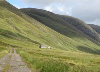 A remote stone-built shooting lodge nestles in the lee of a Scottish mountainside.