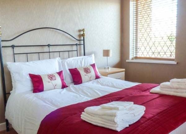 Double bedroom with brass bed and towel sets.