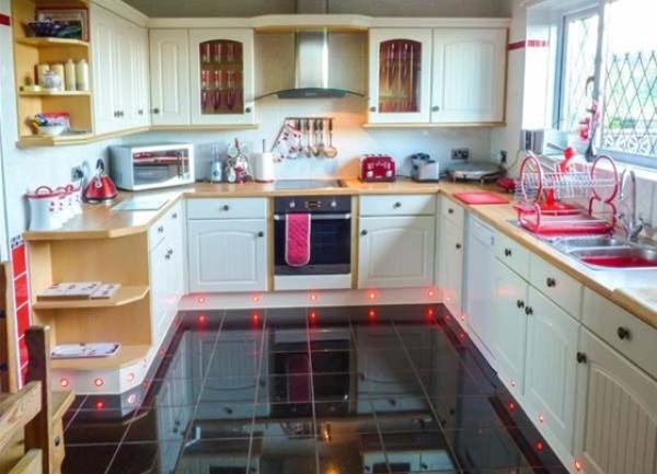 A modern fitted kitchen containing wall-mounted cupboards and worktop sppliance such as a toaster and microwave.