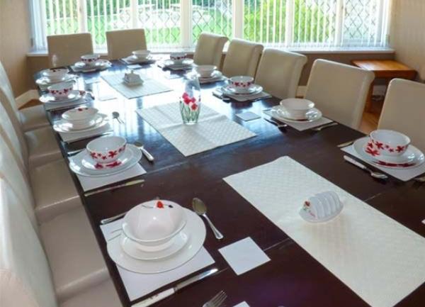 Dining rom with a tablke laid for 10 guests.