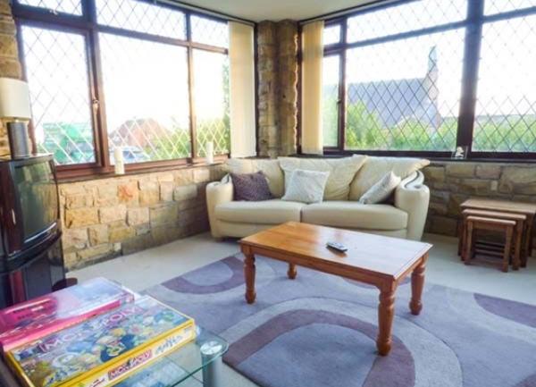 A lounge corner with dual aspect leaded windows, sofa and coffee table.