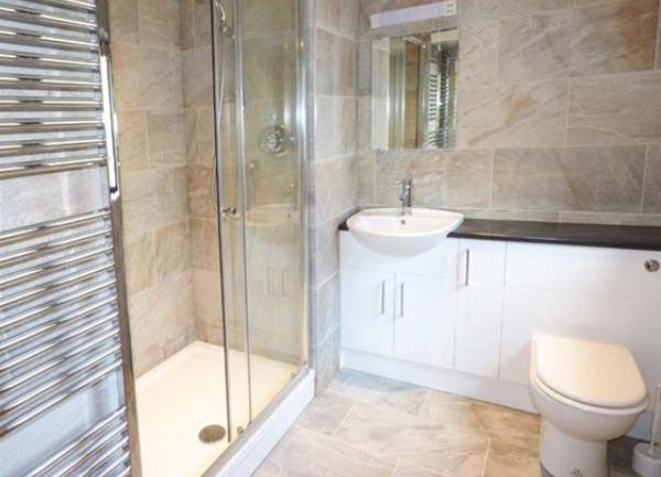 Bathroom with a walk-in shower, washbasin, heated towel rail and WC. and 