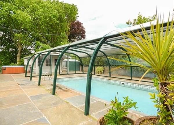 An outdoor swimming pool with a frame allowing it to be covered in winter.