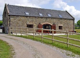 A stone-built barn conversion overlooks a lawned garden.