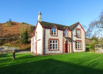 A double-fronted 2-storey house with a large lawn in a moorland location