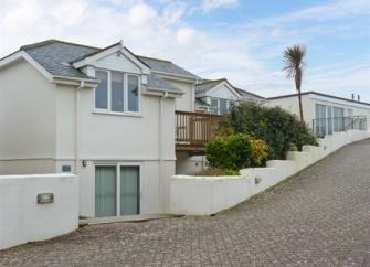 A modern detached house on a quiet hillside, blockpaved road.