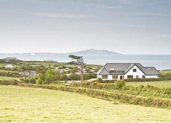 A large chalet bungalow surrounded by fields and overlooking the Anglesey coast.