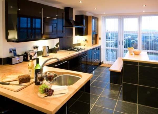 A slate-tiled bespoke fitted kitchen, an Island block and external balcony.
