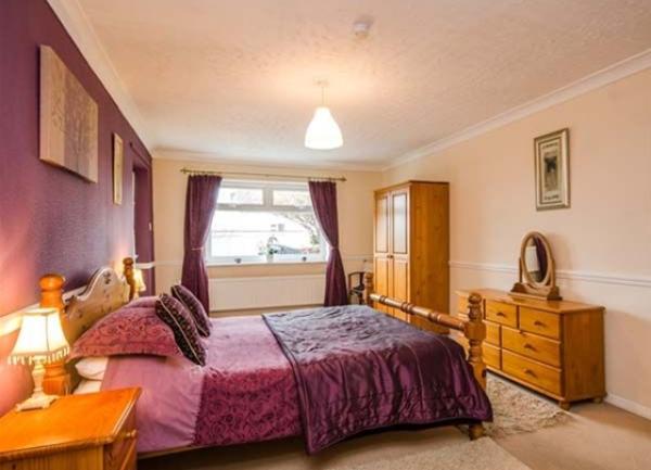 Double bedroom with bed, wardrobe, chest-of-drawers and bedside tables.
