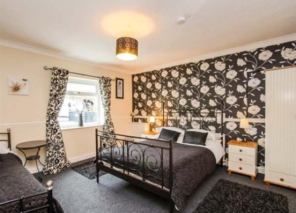 Family bedroom with double and single bed, wardrobe and bedside cabinets.