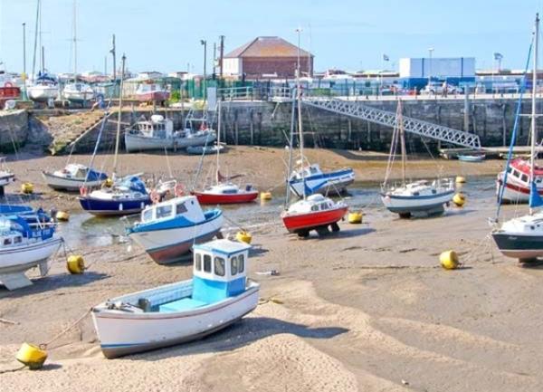 Harbour at low tide with moored pleasure boats.
