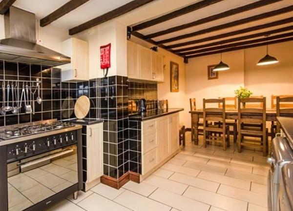Part-tiled, fitted kitchen with large range cooker.