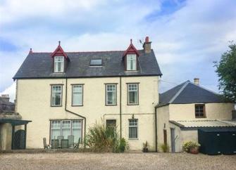 3-storey house with a 2-storey wing and a large parking space in front