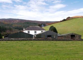 A Northumberland farmhouse in open countryside overlooks a row of traditional barns