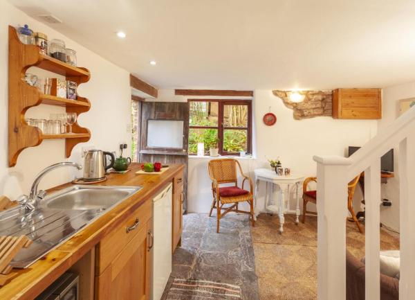Kitchen units with integrated dishwasher lead to a dining area with a table for two.