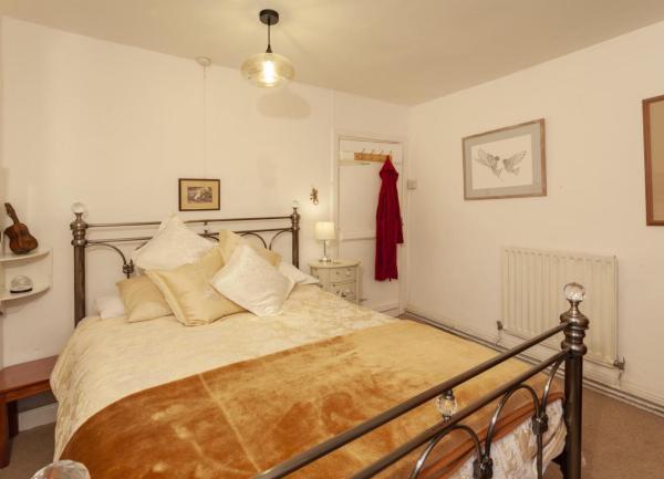 A double bedroom with a bed and bedside tables with wall lights above.