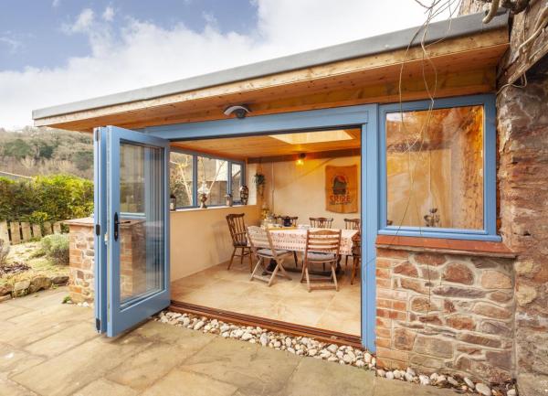 A view from the patio through open bi-fold doors into the dining room.