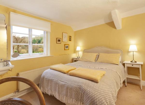 A double bedroom with a washbasin, bedside tables and lamps.