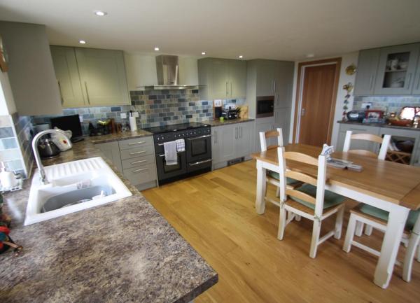 A contemporary kitchen-diner with modern integrated appliances.