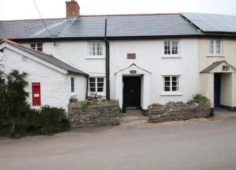 Double-fronted cottage exterior overlooks a quiet village street.