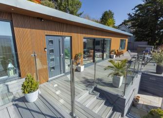 Exterior and deck of a single-storey wooden holiday lodge in Minehead