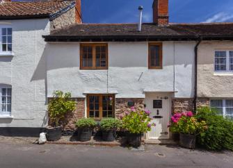 Exterior of a terraced stone-built holiday cottage in Dunster.