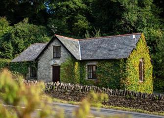 A slate-roofed, ivy-clad stone cottage in the evening sunlight on Exmoor.