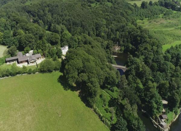Aerial view of cottages nestling in riverside woods.