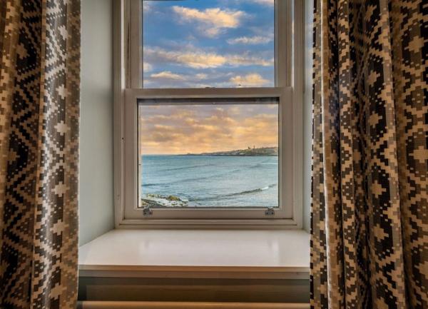 Sunset over the sea seen from a bedroom window.