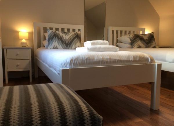 Tein bedroom with beds and bedside cabinets with table lamps.