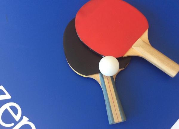 Bats and a ball on a table tennis table.