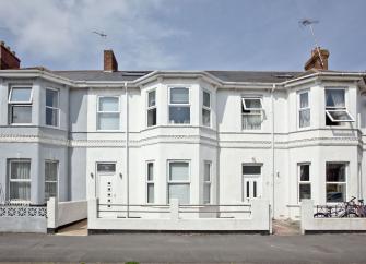 A terraced row of well-maintained Victorian Houses with small low-walled front garden.