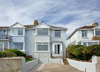 Exterior of a 2 storey detached house overlooking a garden and driveway.