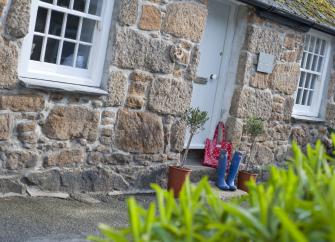 Ground-floor frontage of a stone-built holiday cottage in Mousehole.