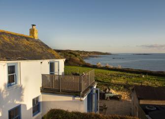 A two storey Marazion holiday cottage overlooks a lawned garden and sweeping sea views.