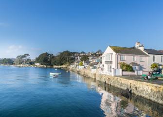 Flushing holiday cottages line the Fal Estuary at high tide.