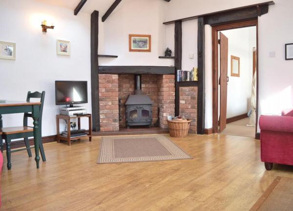 An Exmoor cottage lounge with pine floorboards with an inglenook fireplace.