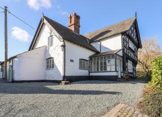 Exterior of a Tudor oak-beamed farmhouse in Shropshire with overhanging gable end
